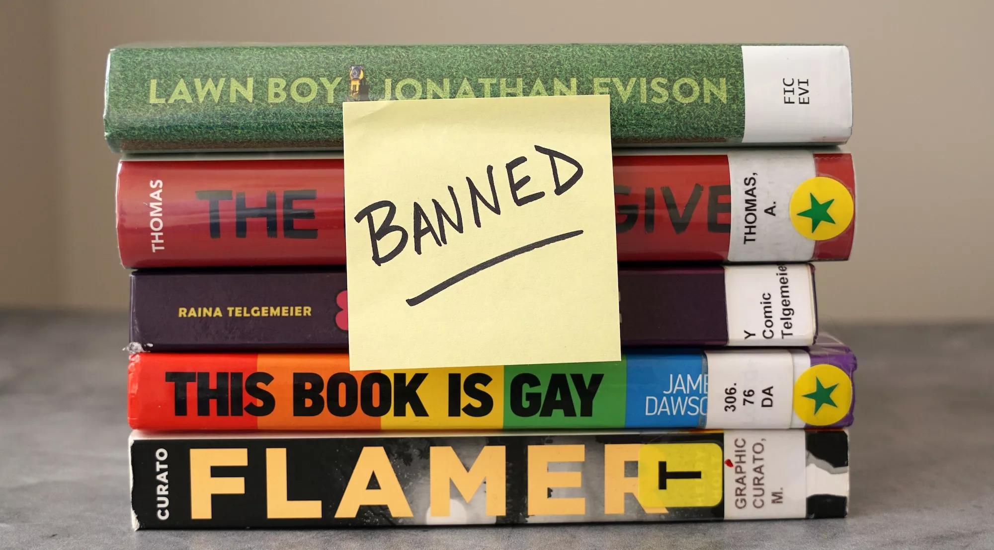 A stack of books frequently found on banned book lists with a sticky note saying "banned"